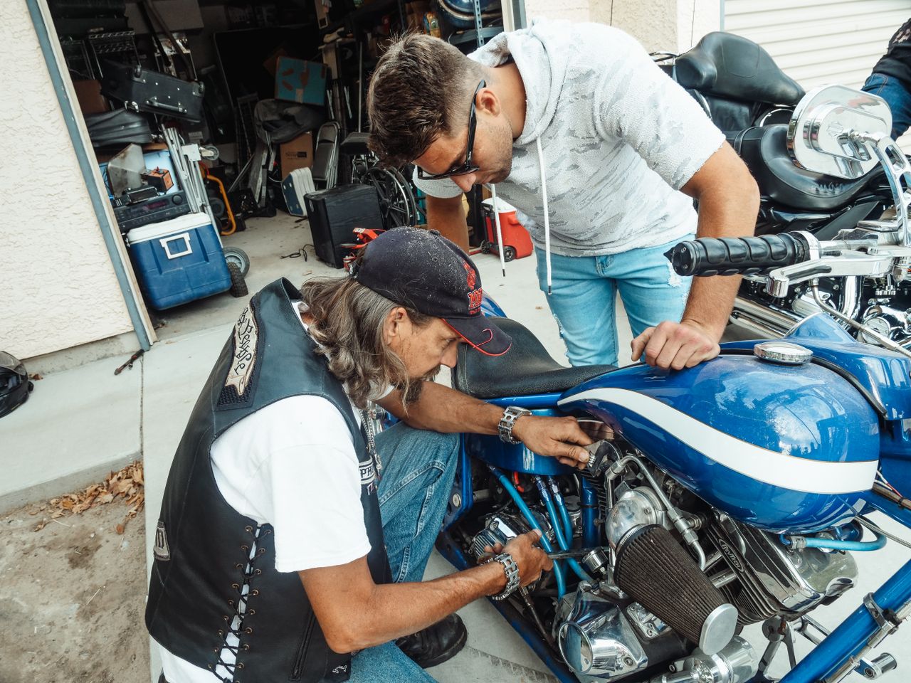 Two technicians carrying out recorded checks on a used motorcycle